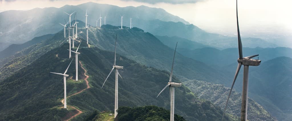Wind turbines along a misty mountain ridge